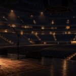Editorial illustration of an empty arena at night with a lone guitar. Not a photo of the venue or any real person.